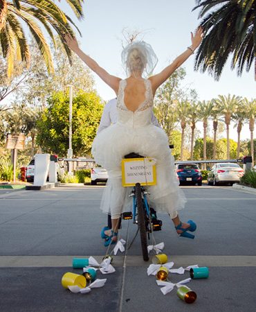 Bride and groom riding off on a motorcycle.
