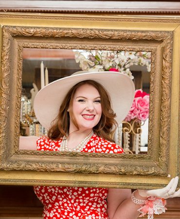 bride to be posing behind a picture frame
