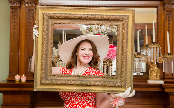 bride to be posing behind a picture frame
